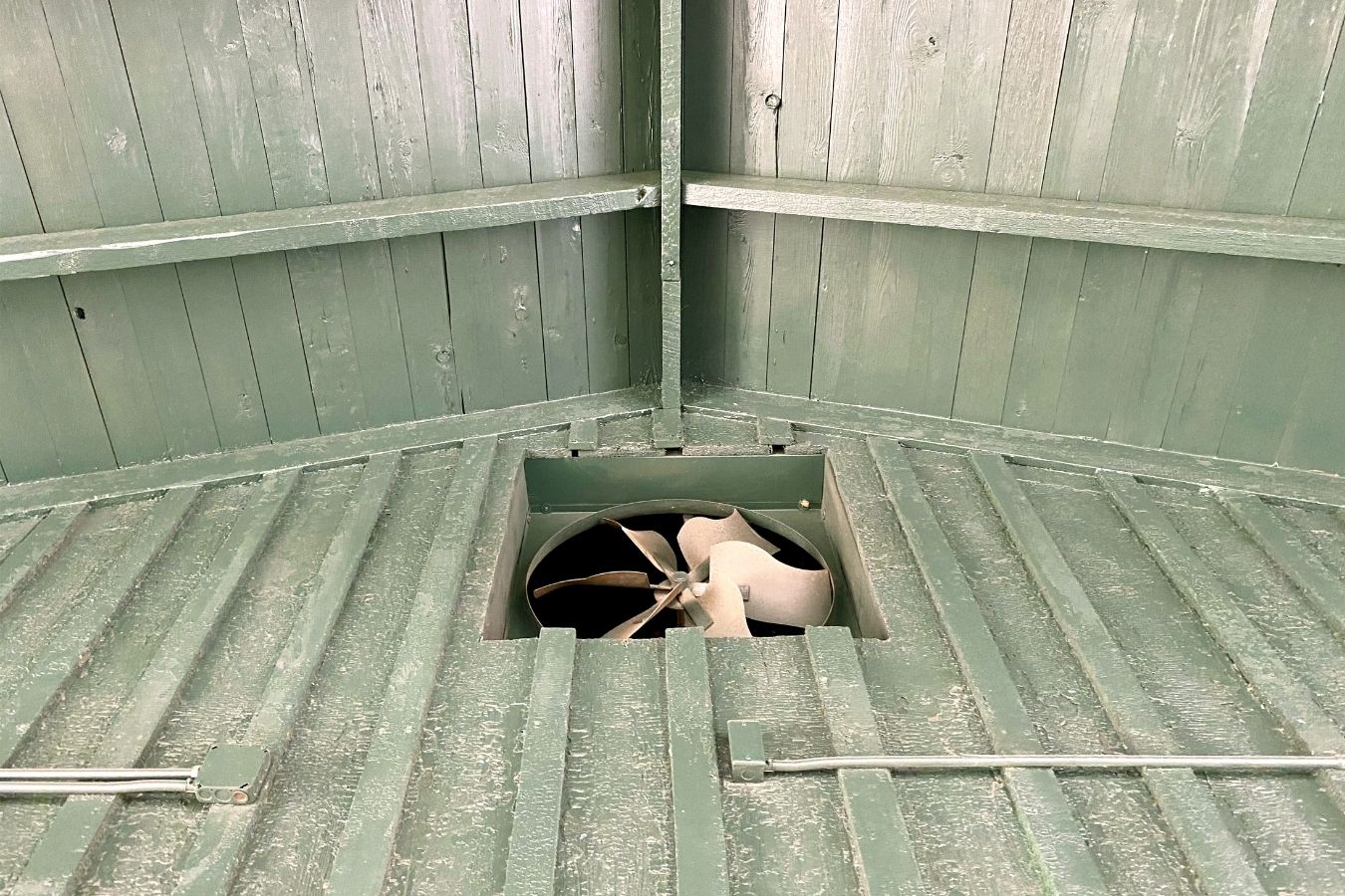 A powered attic fan installed in the attic